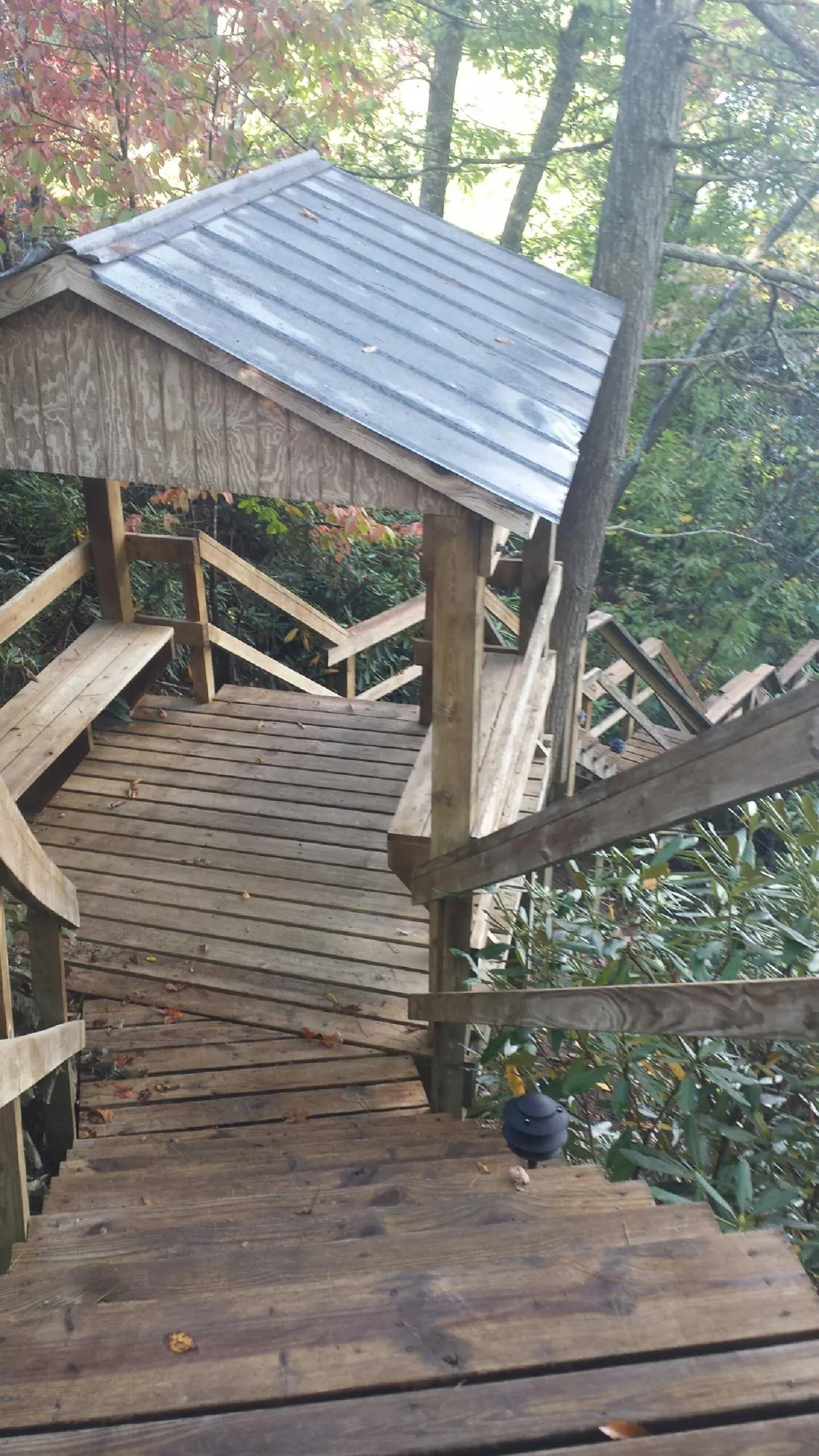 Metal roofed shelter over wooden steps on a wooded walkway — Skylight Repair & Installation work by our crew in Southfield